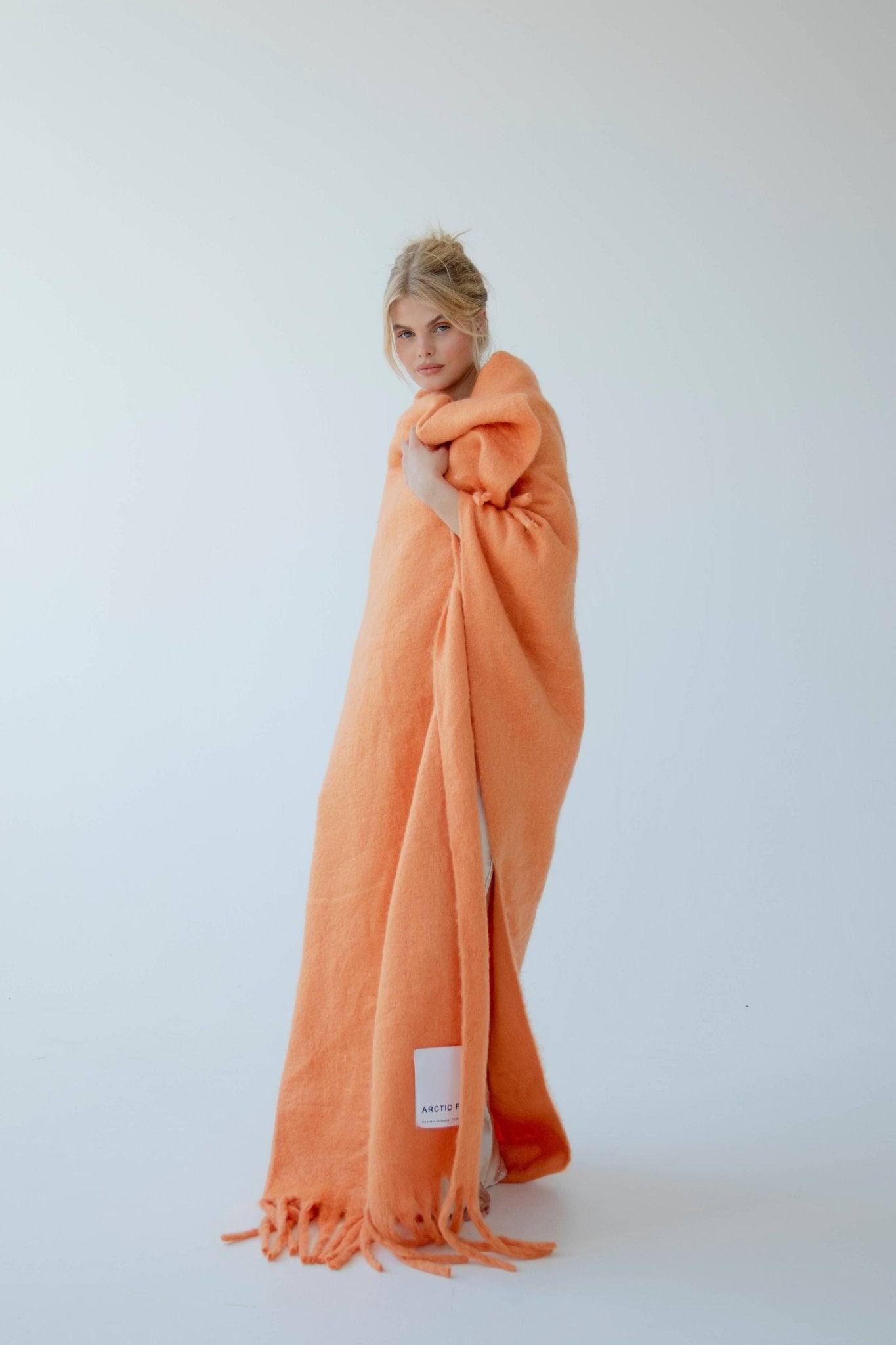 lady wrapped up in a burnt orange blanket