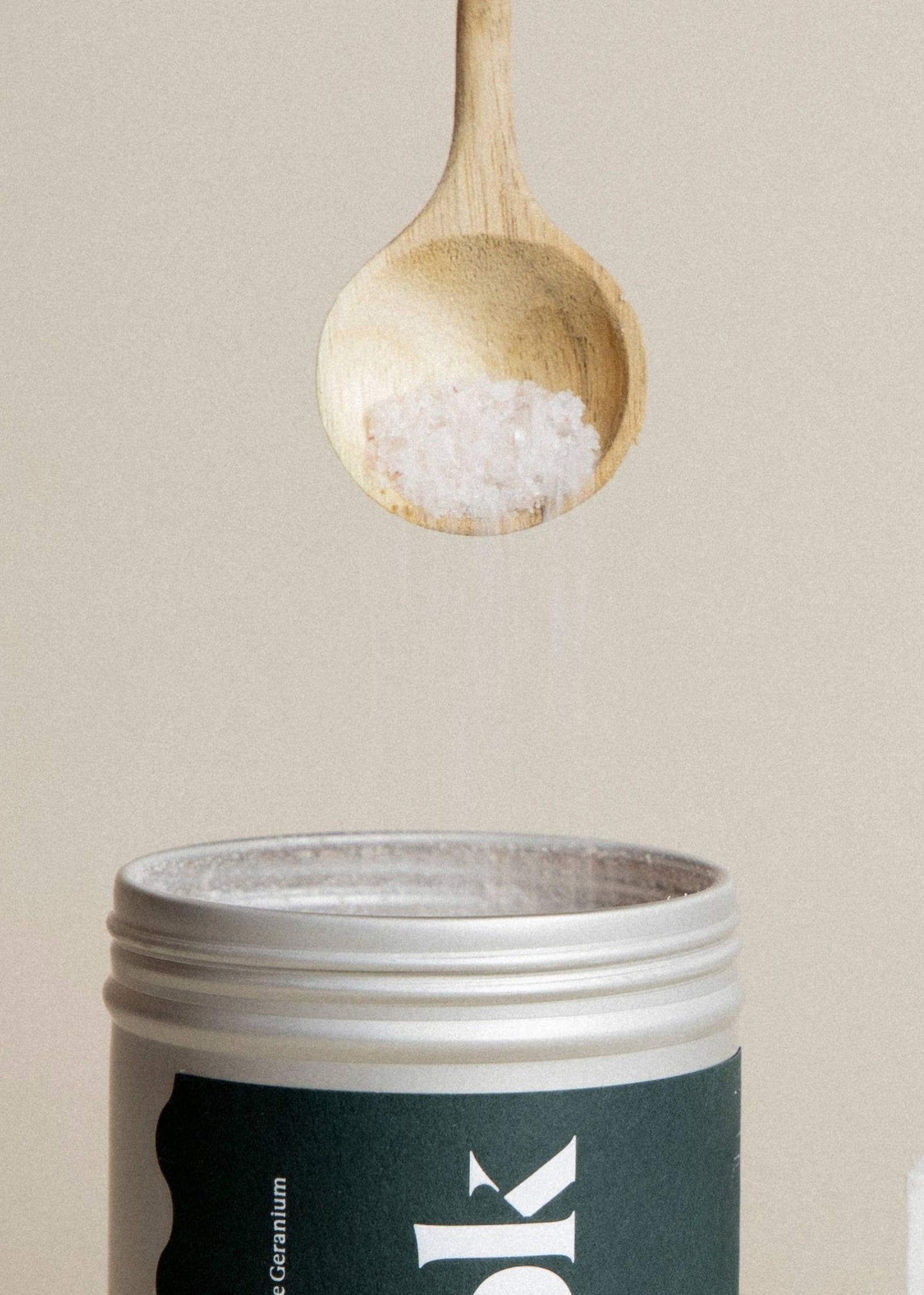 spoon dropping bath salts into a tin