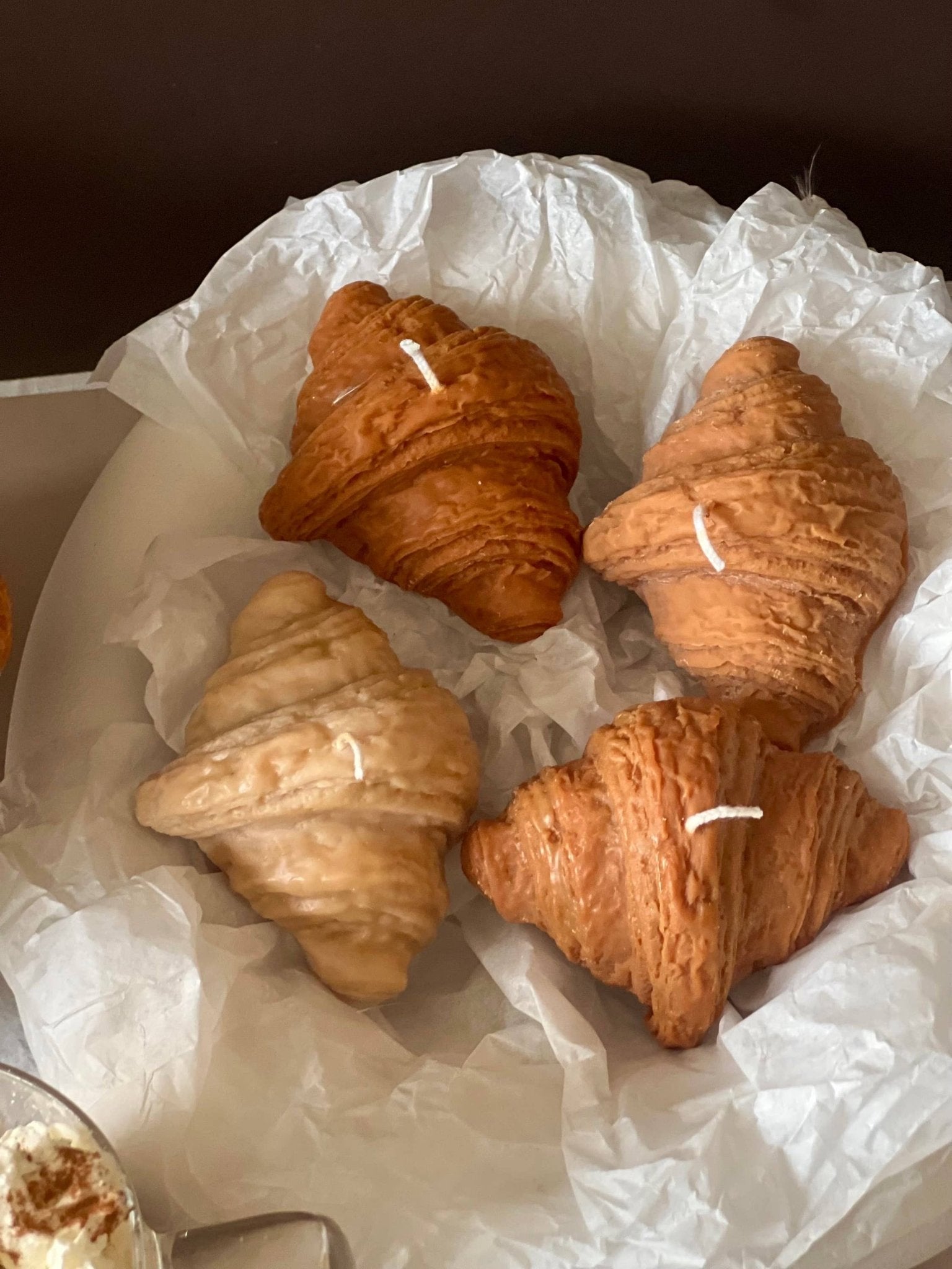 4 croissant shaped candles in white tissue