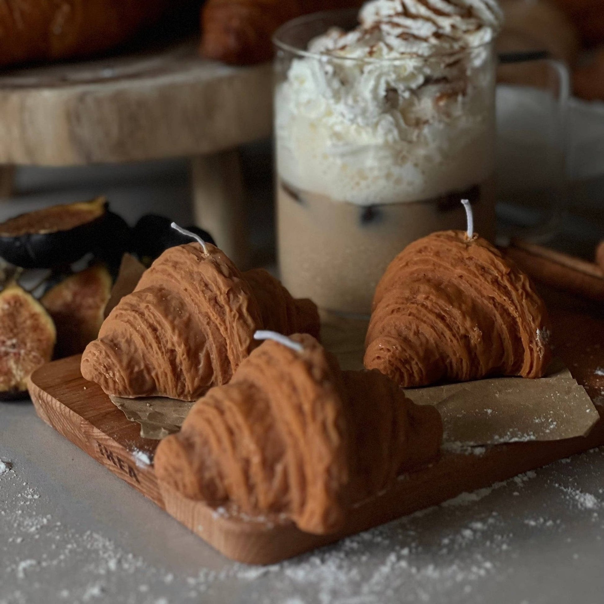 3 croissant shaped candles on a brown wooden tray